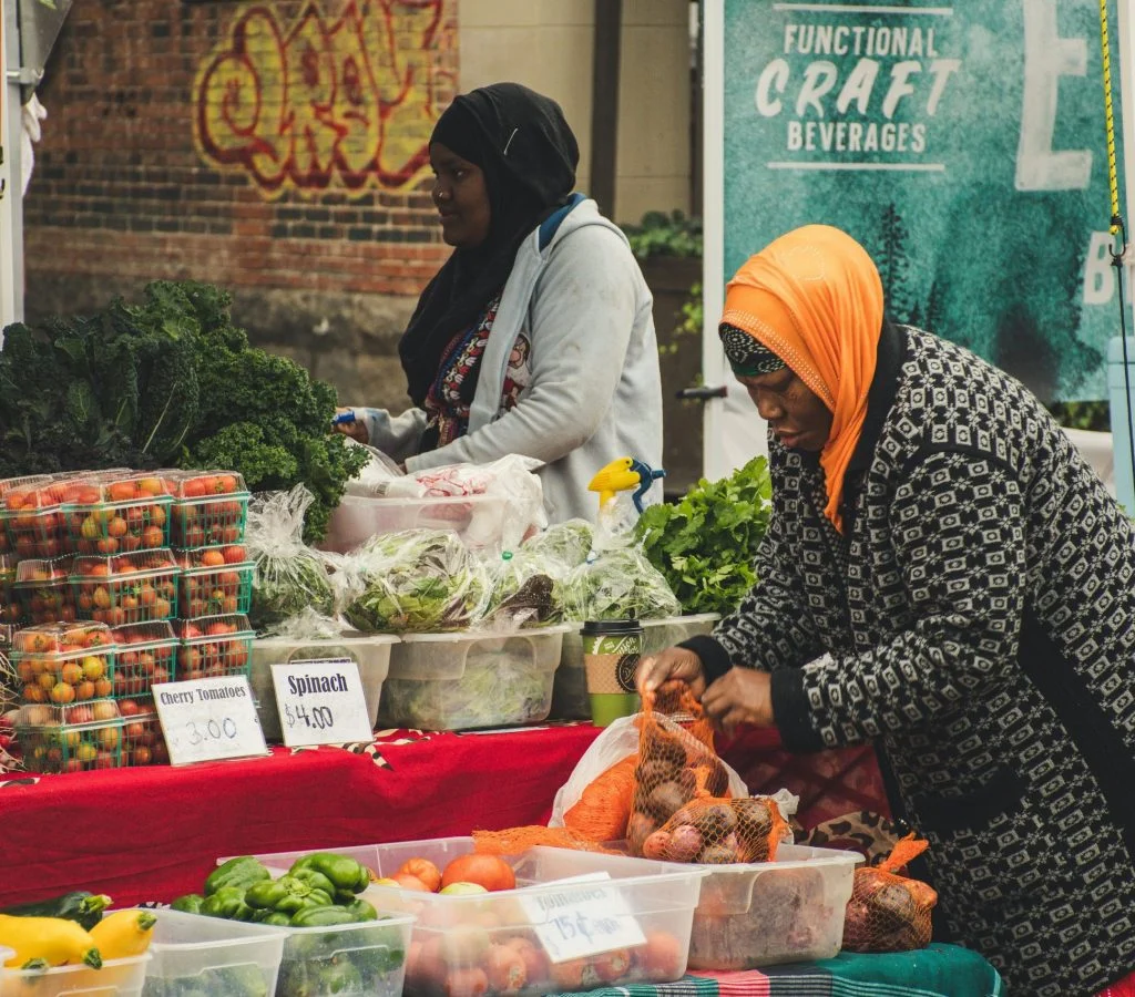 Busy outdoor market scene with people, stalls, and local produce in Canada