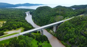 Panoramic view of a bridge crossing in Canada surrounded by lush greenery and mountains