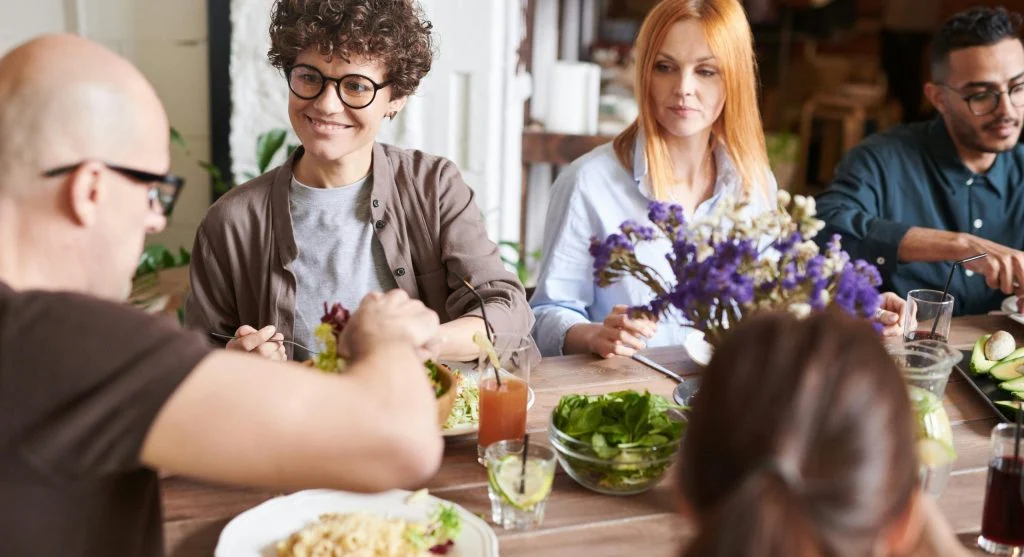 People gathered around shared tables in a community supper setting
